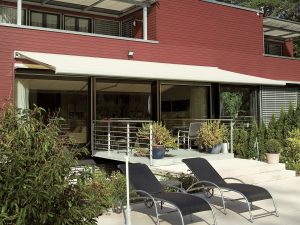 a white weinor awning installed on a red building with a balcony
